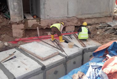 İnşaat İşçileri prekast yeraltı drenaj yüklemek