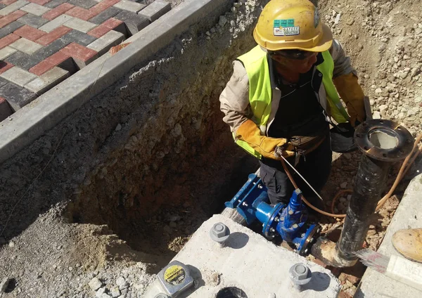 Építőipari munkások, föld alatti csövek rögzítéséről — Stock Fotó