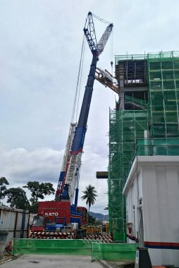 Kuala Lumpur, Malezya-11 Ekim 2016: Vinçler-Mobil vinç ağır malzeme inşaat alanındaki kaldırma için kullanılan ağır makine olduğunu. Malzeme güçlü ve ağır görev kablosu kullanarak asmak oldu.  
