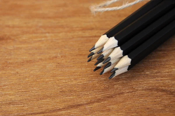 Black Pencils Tied Rope Straw Yarn Backdrop Plywood Wood Pattern — Stock Photo, Image