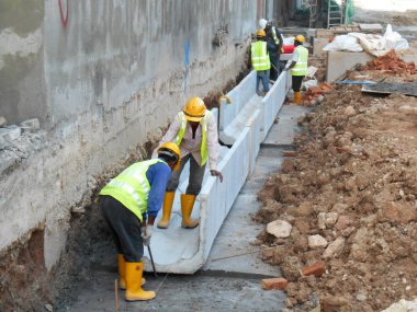 Malacca, Malaysia-31 Ocak 2017: drenaj iş inşaat işçileri tarafından. İnşaat İşçileri prekast u şeklinde beton drenaj inşaat sahasında yükleme. 