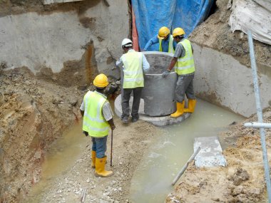 Malacca, Malaysia-31 Ocak 2017: drenaj iş inşaat işçileri tarafından. İnşaat İşçileri prekast u şeklinde beton drenaj inşaat sahasında yükleme. 