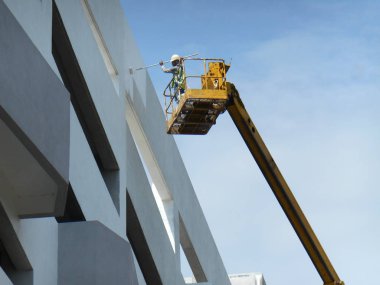 Kuala Lumpur, Malezya-16 Şubat 2017: inşaat işçileri Mobil vinç ayakta kova inşaat alanı içinde yüksek düzeyde çalışırken. Kova hareket işçiler tarafından kendini kontrol. 