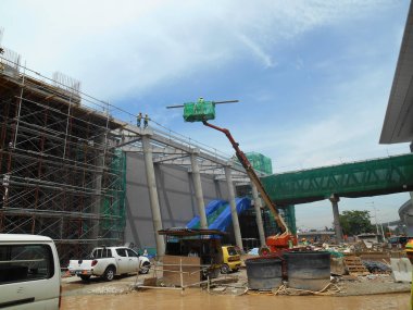 Kuala Lumpur, Malezya-16 Şubat 2017: inşaat işçileri Mobil vinç ayakta kova inşaat alanı içinde yüksek düzeyde çalışırken. Kova hareket işçiler tarafından kendini kontrol. 