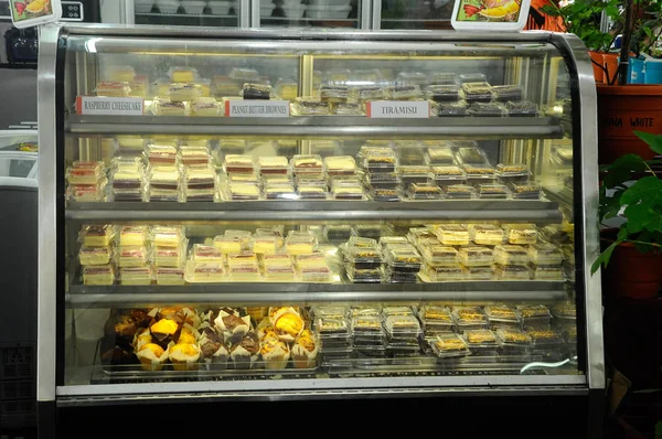 ケーキとケーキのマフィンは 冷凍機を表示します ベーカリー ショップで顧客にそれが表示されます — ストック写真