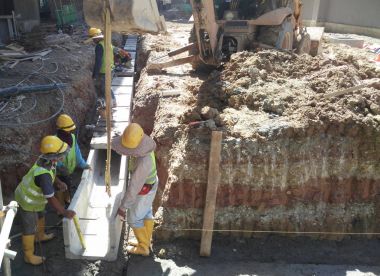 İnşaat İşçileri inşaat sahasında prekast yeraltı drenaj yüklemek.