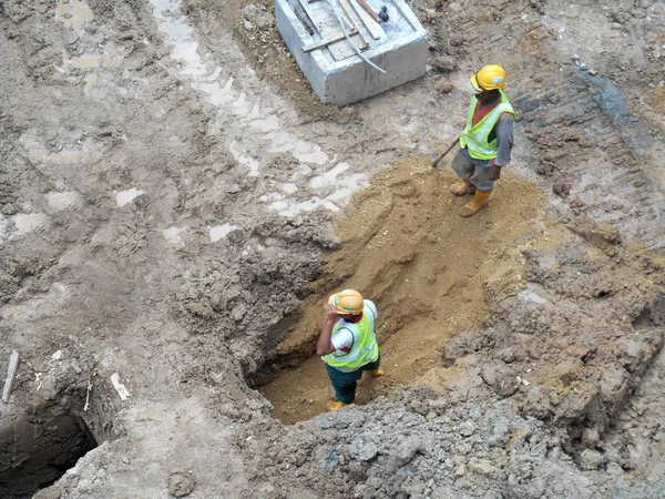 Trabalhadores da construção instalam dreno subterrâneo pré-moldado no canteiro de obras . — Fotografia de Stock