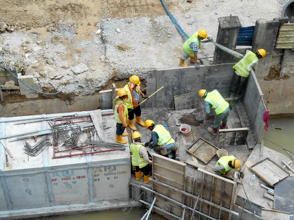 Construction workers install precast underground drain at the construction site. — Stock Photo, Image
