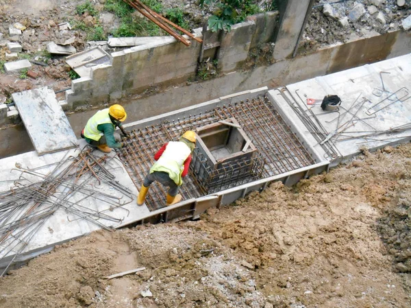 Bauarbeiter verlegen unterirdischen Fertigteilabfluss auf der Baustelle. — Stockfoto