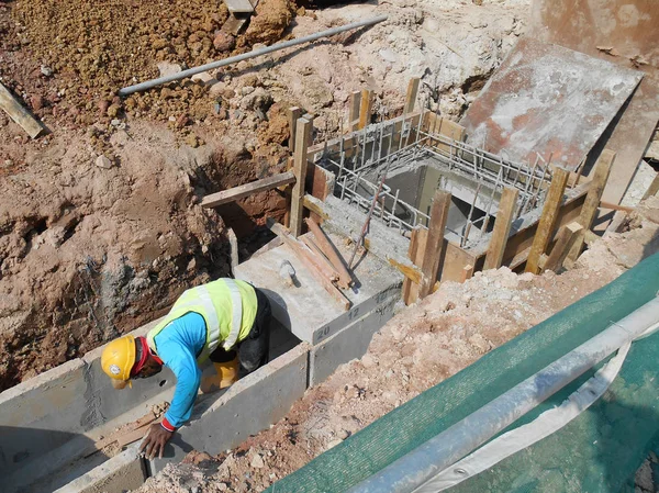 Trabajadores de la construcción instalan drenaje subterráneo prefabricado en el sitio de construcción . — Foto de Stock