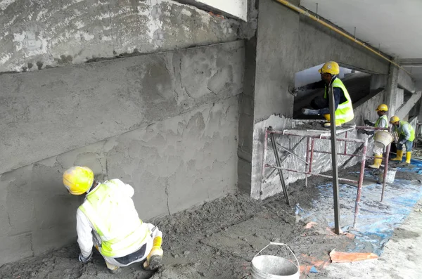 しっくいの建物の壁と梁のセメントを使用した左官工事建設労働者 — ストック写真