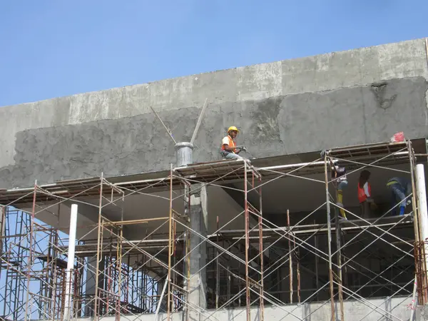 Bauarbeiter verputzen Hauswand und Balken mit Zementputz — Stockfoto
