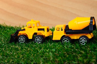 Suni çim izole plastik ağır inşaat makine oyuncaklar. 