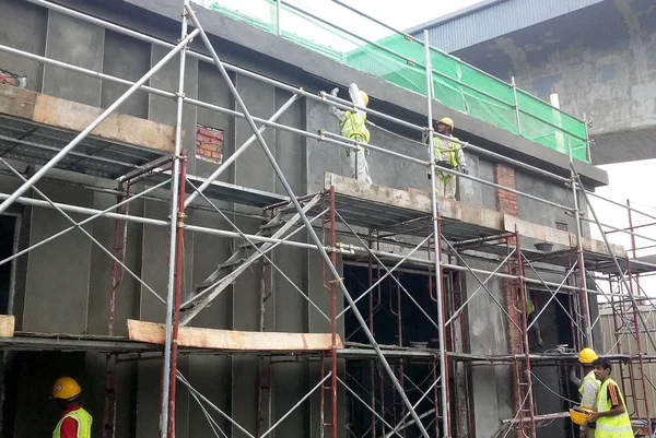 建物の壁 Jasin マレーシアの建設現場にセメントと砂のセメント石膏ミックスを用いた梁部材を左官工事建設労働者 — ストック写真