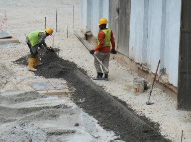 Kuala Lumpur, Malezya-06 Şubat 2017: Beton yol kaldırım inşaat sahasında imalatı inşaat işçileri. İn-situ yöntemi kullanıyorlar ve yapılmış ve metal kalıp kullanarak. 