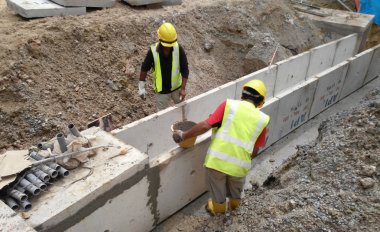 Malacca, Malaysia-31 Ocak 2017: inşaat işçileri prekast u şeklinde beton drenaj inşaat sahasında yükleme. Drenaj fabrikada imal edilmiştir ve siteye seferber. 