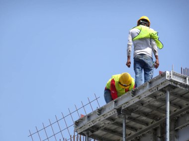 Kuala Lumpur, Malezya-07 Temmuz 2017: inşaat işçileri yükseklikte inşaat alanında çalışıyor. İskele geçici platformu olarak çalışmak için kullanma. Onlar uygun güvenlik dişli giymek için gerekli olan. 