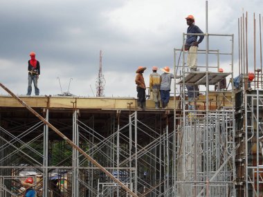 Kuala Lumpur, Malezya-07 Temmuz 2017: inşaat işçileri yükseklikte inşaat alanında çalışıyor. İskele geçici platformu olarak çalışmak için kullanma. Onlar uygun güvenlik dişli giymek için gerekli olan. 
