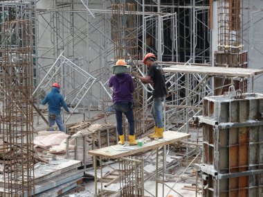 Kuala Lumpur, Malezya-07 Temmuz 2017: inşaat işçileri yükseklikte inşaat alanında çalışıyor. İskele geçici platformu olarak çalışmak için kullanma. Onlar uygun güvenlik dişli giymek için gerekli olan. 