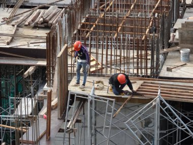 Kuala Lumpur, Malezya-07 Temmuz 2017: inşaat işçileri yükseklikte inşaat alanında çalışıyor. İskele geçici platformu olarak çalışmak için kullanma. Onlar uygun güvenlik dişli giymek için gerekli olan. 