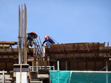 Kuala Lumpur, Malezya-07 Temmuz 2017: inşaat işçileri yükseklikte inşaat alanında çalışıyor. İskele geçici platformu olarak çalışmak için kullanma. Onlar uygun güvenlik dişli giymek için gerekli olan. 