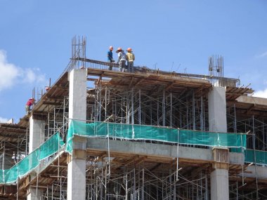 Kuala Lumpur, Malezya-07 Temmuz 2017: inşaat işçileri yükseklikte inşaat alanında çalışıyor. İskele geçici platformu olarak çalışmak için kullanma. Onlar uygun güvenlik dişli giymek için gerekli olan. 