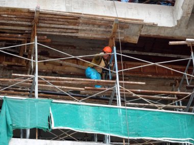 Kuala Lumpur, Malezya-07 Temmuz 2017: inşaat işçileri yükseklikte inşaat alanında çalışıyor. İskele geçici platformu olarak çalışmak için kullanma. Onlar uygun güvenlik dişli giymek için gerekli olan. 