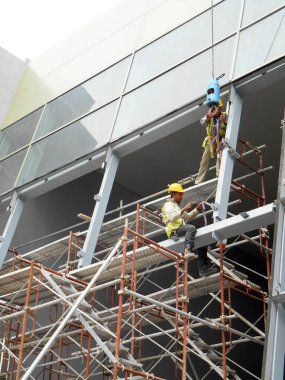 Kuala Lumpur, Malezya-07 Temmuz 2017: inşaat işçileri yükseklikte inşaat alanında çalışıyor. İskele geçici platformu olarak çalışmak için kullanma. Onlar uygun güvenlik dişli giymek için gerekli olan. 