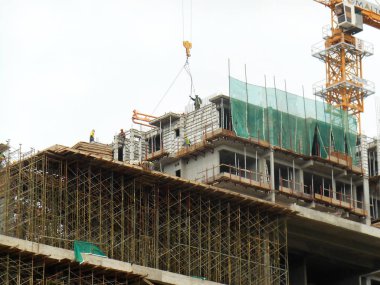 Kuala Lumpur, Malezya-07 Temmuz 2017: inşaat işçileri yükseklikte inşaat alanında çalışıyor. İskele geçici platformu olarak çalışmak için kullanma. Onlar uygun güvenlik dişli giymek için gerekli olan. 
