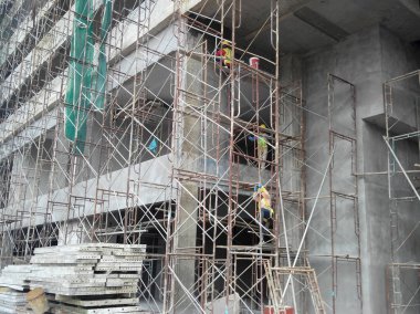 Kuala Lumpur, Malezya-07 Temmuz 2017: inşaat işçileri yükseklikte inşaat alanında çalışıyor. İskele geçici platformu olarak çalışmak için kullanma. Onlar uygun güvenlik dişli giymek için gerekli olan. 