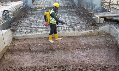 Kuala Lumpur, Malezya - 29 Haziran 2017: İnşaat işçileri termit karşıtı kimyasal tedaviyi inşaat alanındaki toprağa karıştırıp püskürtüyorlar. 