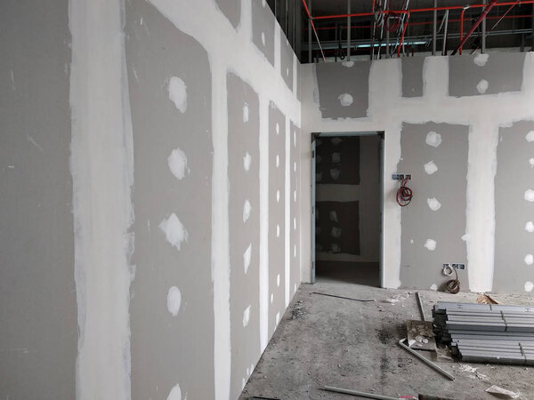 KUALA LUMPUR, MALAYSIA -APRIL 12, 2018: Drywall installation work in progress by construction workers at the construction site. It is the easiest and cheapest way to do partition for interior wall. 