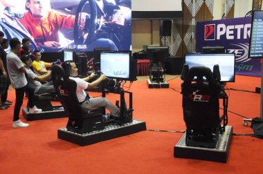 Kuala Lumpur, Malezya - 8 Nisan 2017: Büyük ekran monitörlü ve yarış arabası gibi kokpit kontrollü yarış arabası oyunu simülasyonu.