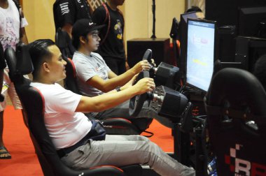 Kuala Lumpur, Malezya - 8 Nisan 2017: Büyük ekran monitörlü ve yarış arabası gibi kokpit kontrollü yarış arabası oyunu simülasyonu.