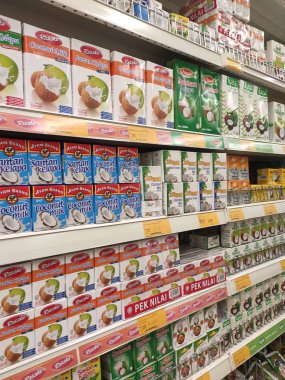 Kuala Lumpur, Malezya -14 Aralık 2019: İşlenmiş hindistan cevizi sütü kağıt kutuda paketlenmiş ve süpermarketin içindeki çelik bir rafta sergilenmektedir. Markaya göre sıralanır. 