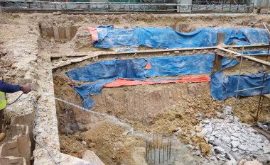 Kuala Lumpur, Malezya - 29 Haziran 2017: İnşaat işçileri termit karşıtı kimyasal tedaviyi inşaat alanındaki toprağa karıştırıp püskürtüyorlar. 