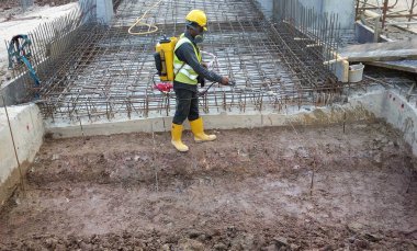 Kuala Lumpur, Malezya - 29 Haziran 2017: İnşaat işçileri termit karşıtı kimyasal tedaviyi inşaat alanındaki toprağa karıştırıp püskürtüyorlar. 