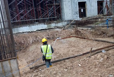 Kuala Lumpur, Malezya - 29 Haziran 2017: İnşaat işçileri termit karşıtı kimyasal tedaviyi inşaat alanındaki toprağa karıştırıp püskürtüyorlar. 