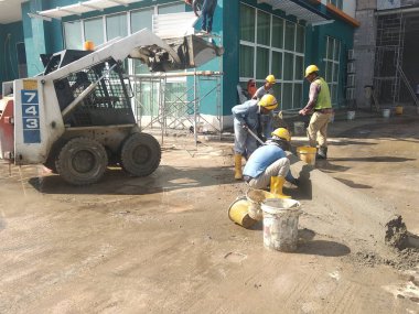 KUALA LUMPUR, MALAYSIA -NOVEMBER 02, 2018: Construction workers fabricating concrete road kerb at the construction site. They are using the in-situ method using the standard metal mould. 