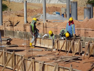 KUALA LUMPUR, MALAYSIA -MARCH, 2019: Construction workers installing & fabricating ground beam timber form works at the construction site. The formworks made from timber and plywood. 
