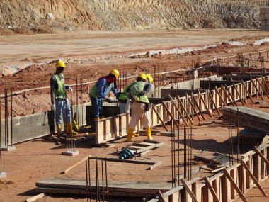 KUALA LUMPUR, MALAYSIA -MARCH, 2019: Construction workers installing & fabricating ground beam timber form works at the construction site. The formworks made from timber and plywood. 