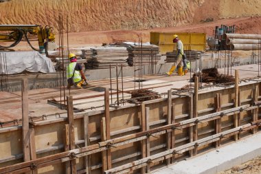 KUALA LUMPUR, MALAYSIA -MARCH, 2019: Construction workers installing & fabricating ground beam timber form works at the construction site. The formworks made from timber and plywood. 