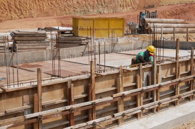 KUALA LUMPUR, MALAYSIA -MARCH, 2019: Construction workers installing & fabricating ground beam timber form works at the construction site. The formworks made from timber and plywood. 