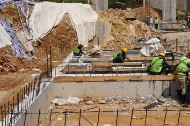 KUALA LUMPUR, MALAYSIA -MARCH, 2019: Construction workers installing & fabricating ground beam timber form works at the construction site. The formworks made from timber and plywood. 