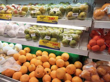 Kuala Lumpur, Malezya - 26 Ekim 2019: Meyveler plastik kapta ve plastik ambalajda paketlenmiştir. Büyük süpermarketin içindeki soğutucu rafında satılık.. 