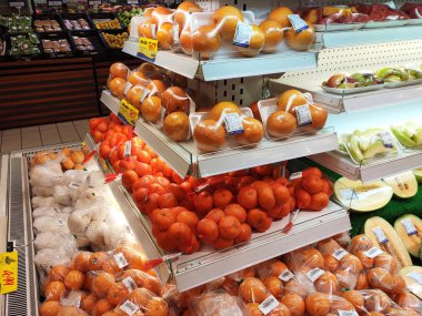 Kuala Lumpur, Malezya - 26 Ekim 2019: Meyveler plastik kapta ve plastik ambalajda paketlenmiştir. Büyük süpermarketin içindeki soğutucu rafında satılık.. 