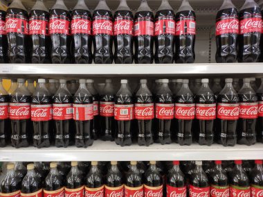 Kuala Lumpur, Malezya - 15 Ekim 2018: Büyük şişelerde kola içilen içecekler büyük bir süpermarkette satılmak üzere rafta sergilenmektedir. Yüksek taleplere göre büyük miktarlarda yerleştirilmiştir.
