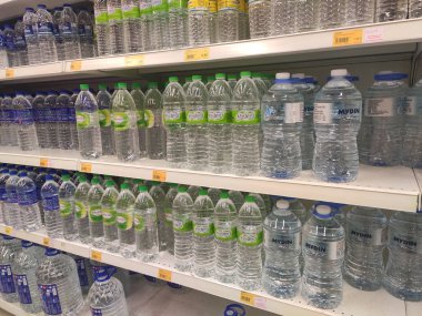 Kuala Lumpur, Malezya - 26 Ekim 2019: Maden suyu paketlendi ve plastik şişelerde çeşitli markalarla etiketlendi. Süpermarketin içindeki bir rafta gösteriliyor.