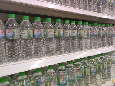Kuala Lumpur, Malezya - 26 Ekim 2019: Maden suyu paketlendi ve plastik şişelerde çeşitli markalarla etiketlendi. Süpermarketin içindeki bir rafta gösteriliyor.