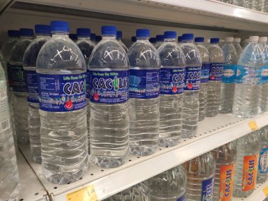 Kuala Lumpur, Malezya - 26 Ekim 2019: Maden suyu paketlendi ve plastik şişelerde çeşitli markalarla etiketlendi. Süpermarketin içindeki bir rafta gösteriliyor.